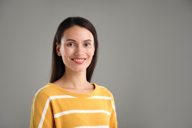 Photo of Portrait of beautiful woman on light grey background. Space for text