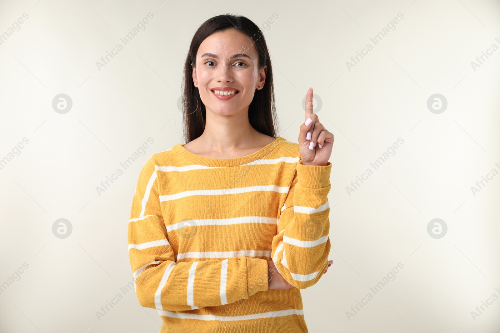 Photo of Beautiful woman having idea on light background