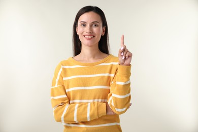 Photo of Beautiful woman having idea on light background