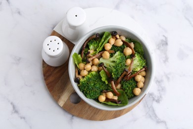 Photo of Delicious salad with shimeji mushrooms, chickpeas and broccoli in bowl on white marble table, top view