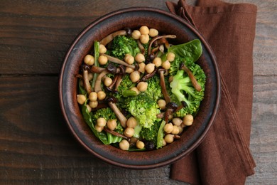 Photo of Delicious salad with shimeji mushrooms, chickpeas and broccoli in bowl on wooden table, top view