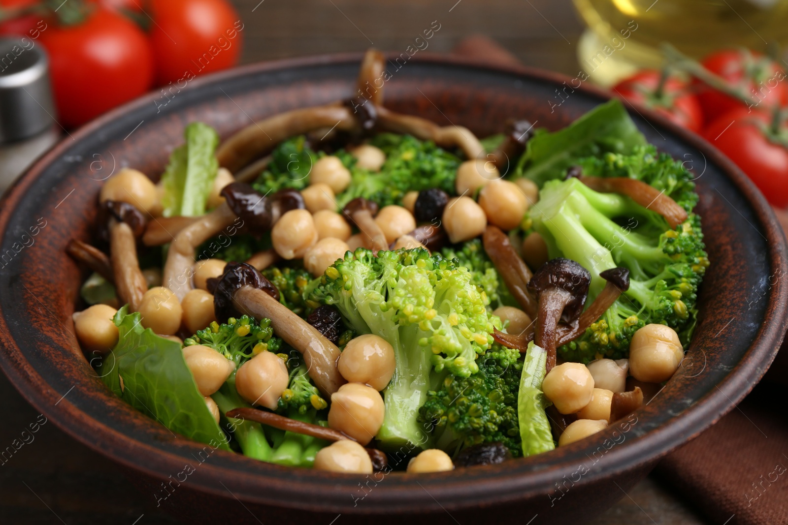 Delicious salad with shimeji mushrooms, chickpeas and broccoli in bowl on table, closeup Photo of Delicious salad with shimeji mushrooms, chickpeas and broccoli in bowl on table, closeup