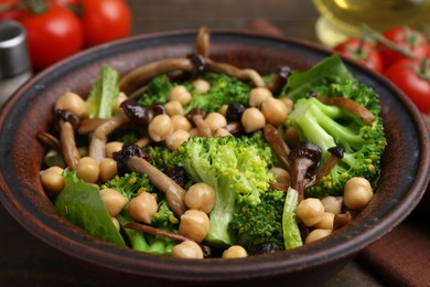 Photo of Delicious salad with shimeji mushrooms, chickpeas and broccoli in bowl on table, closeup