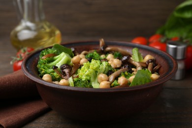 Photo of Delicious salad with shimeji mushrooms, chickpeas and broccoli served on wooden table, closeup