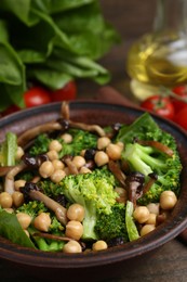 Photo of Delicious salad with shimeji mushrooms, chickpeas and broccoli in bowl on table, closeup