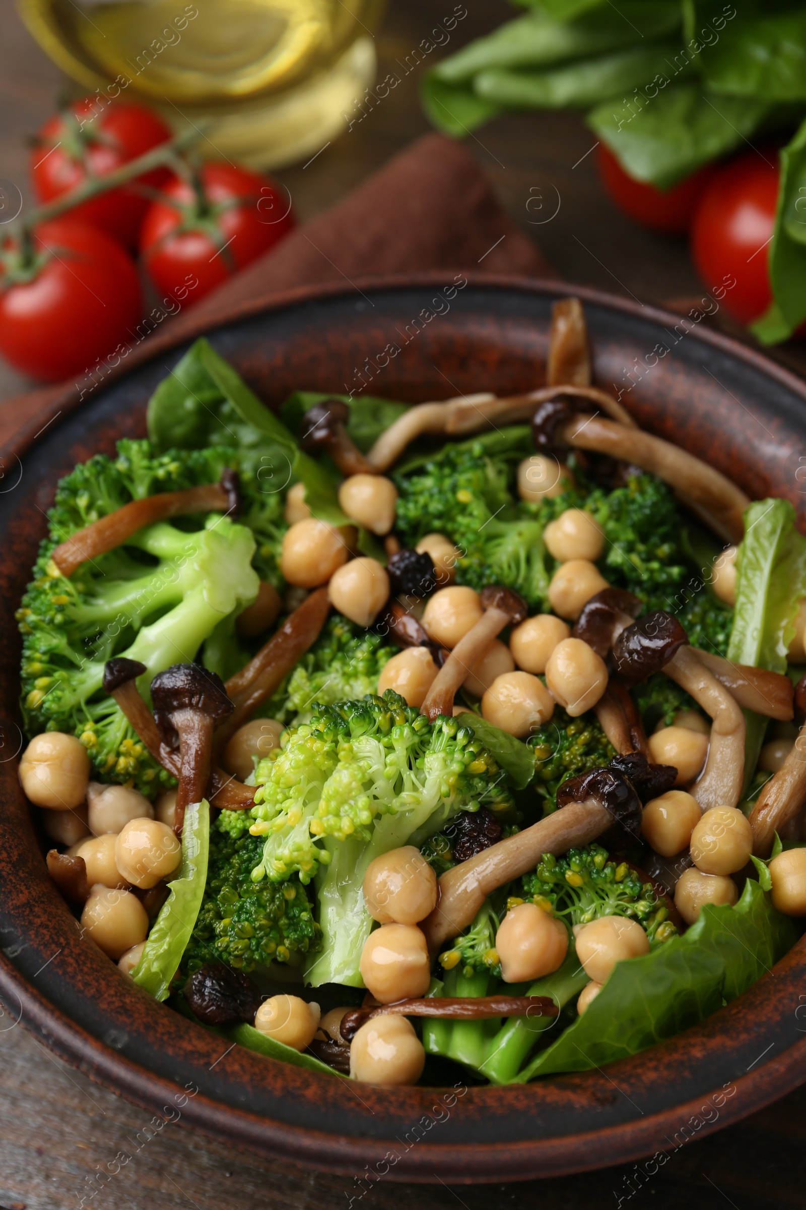 Photo of Delicious salad with shimeji mushrooms, chickpeas and broccoli in bowl on table, closeup