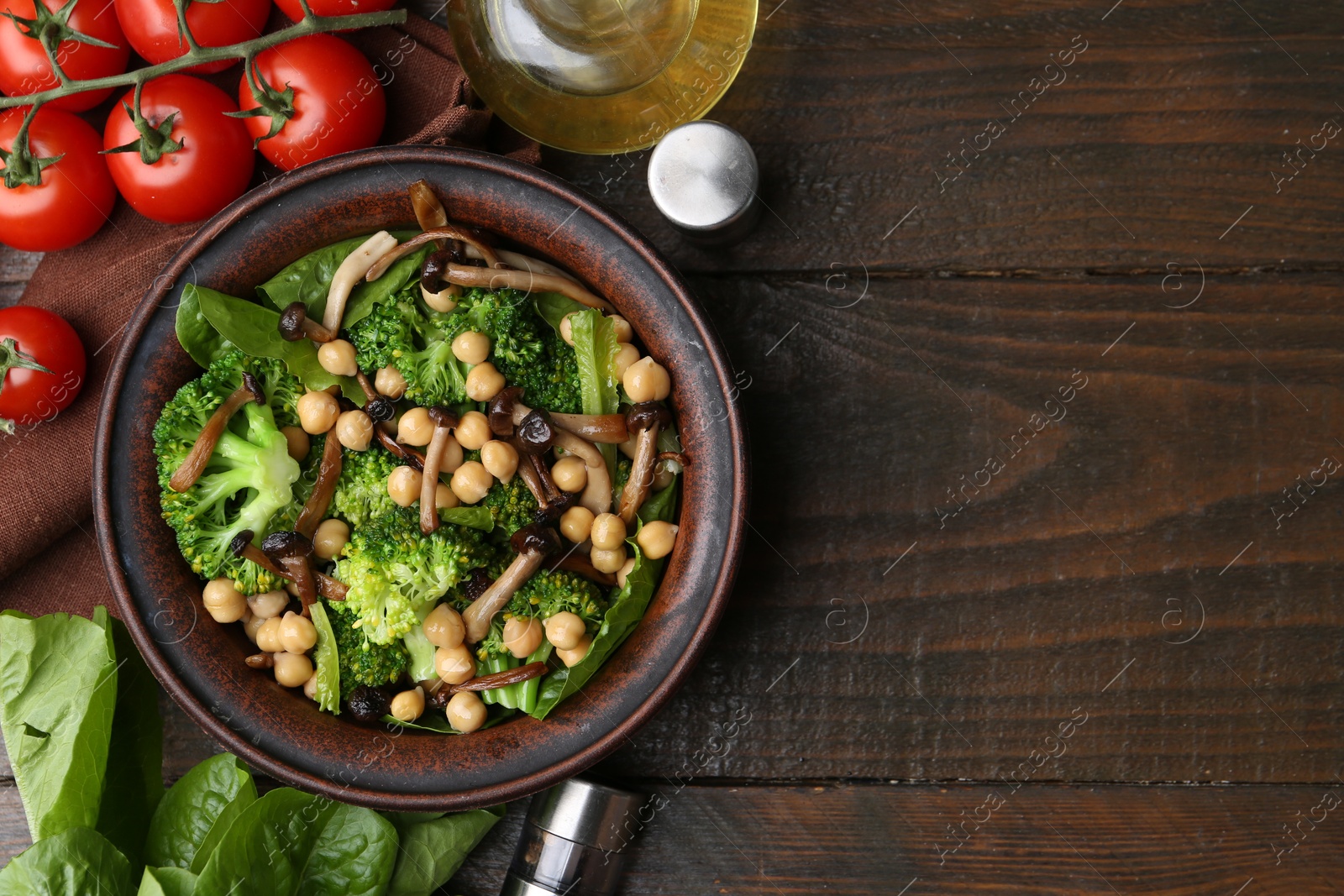 Photo of Delicious salad with shimeji mushrooms, chickpeas and broccoli served on wooden table, flat lay. Space for text