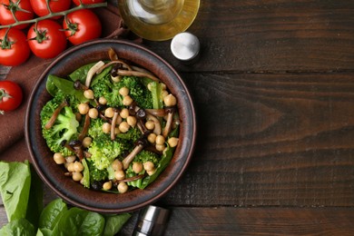 Photo of Delicious salad with shimeji mushrooms, chickpeas and broccoli served on wooden table, flat lay. Space for text