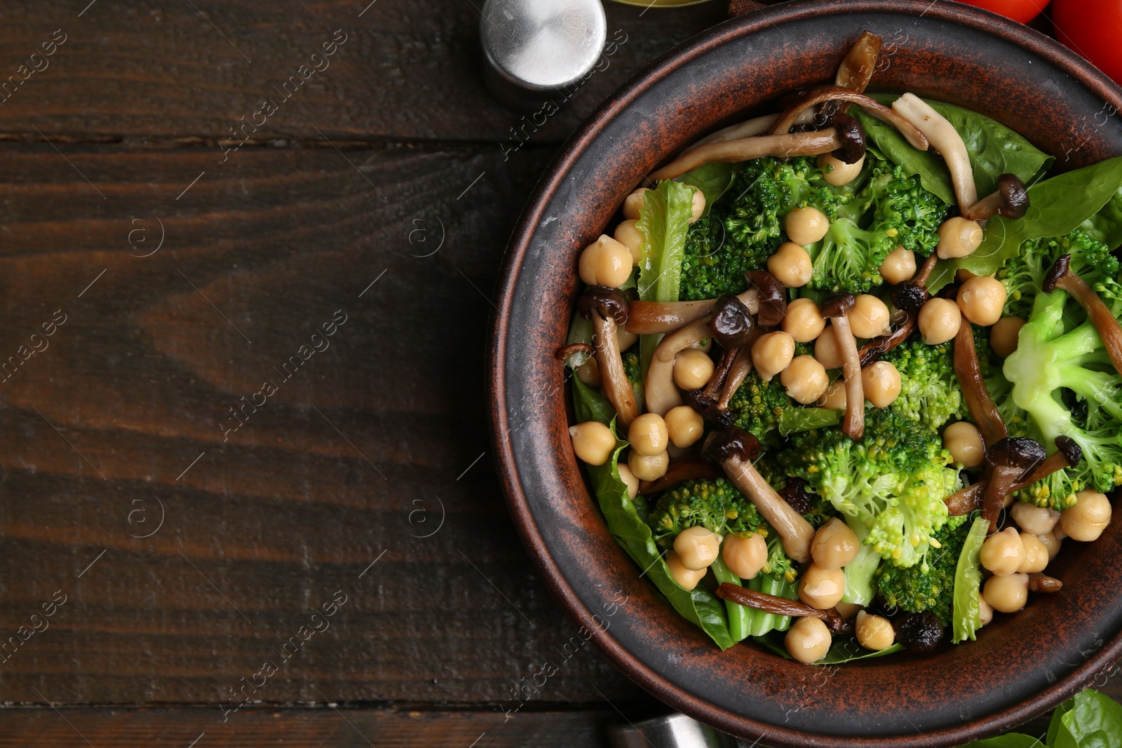 Photo of Delicious salad with shimeji mushrooms, chickpeas and broccoli on wooden table, top view. Space for text