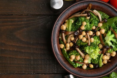 Photo of Delicious salad with shimeji mushrooms, chickpeas and broccoli on wooden table, top view. Space for text