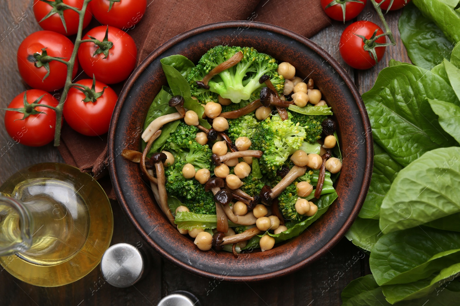 Photo of Delicious salad with shimeji mushrooms, chickpeas and broccoli served on wooden table, flat lay