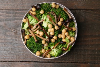 Photo of Delicious salad with shimeji mushrooms, chickpeas and broccoli in bowl on wooden table, top view