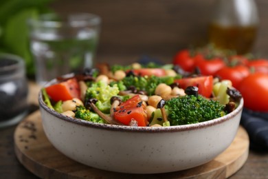 Photo of Delicious salad with shimeji mushrooms, chickpeas, tomatoes and broccoli on table, closeup