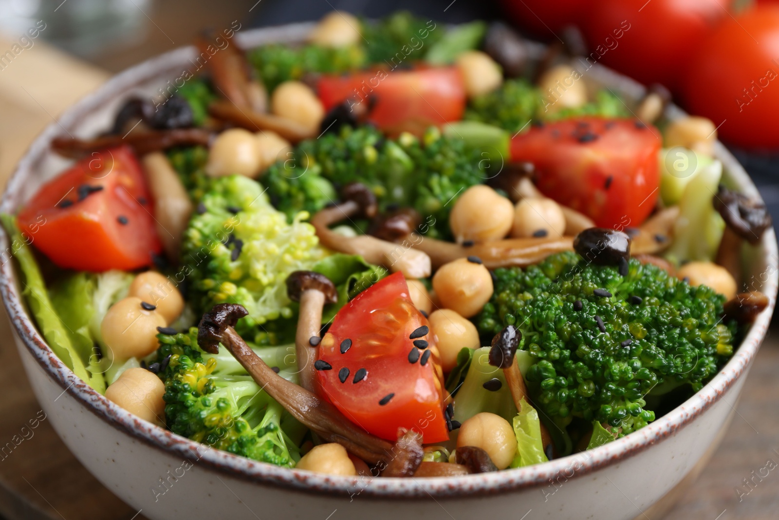 Delicious salad with shimeji mushrooms, chickpeas, tomatoes and broccoli in bowl on table, closeup Photo of Delicious salad with shimeji mushrooms, chickpeas, tomatoes and broccoli in bowl on table, closeup
