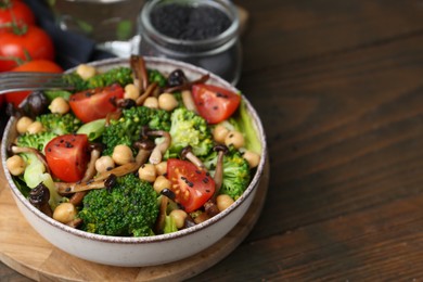Photo of Delicious salad with shimeji mushrooms, chickpeas, tomatoes and broccoli on wooden table, closeup. Space for text