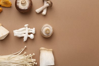 Photo of Different raw mushrooms on beige background, flat lay. Space for text