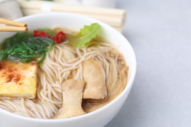 Photo of Tasty ramen with enoki and king oyster (eryngii) mushrooms on white table