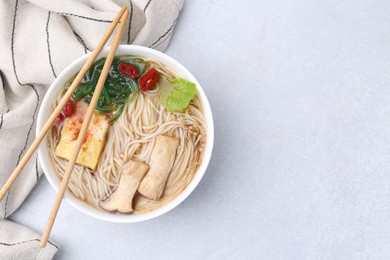 Photo of Tasty ramen with enoki and king oyster (eryngii) mushrooms on white table, top view