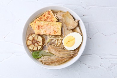 Photo of Tasty ramen with enoki and king oyster (eryngii) mushrooms on white table, top view