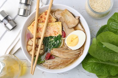 Photo of Tasty ramen with enoki and king oyster (eryngii) mushrooms on white table, flat lay