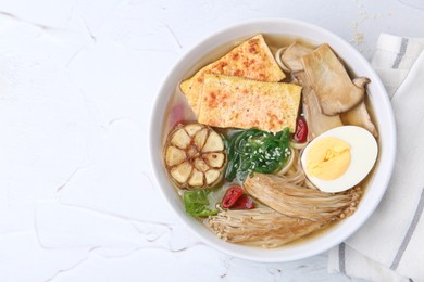 Photo of Tasty ramen with enoki and king oyster (eryngii) mushrooms on white table, top view. Space for text