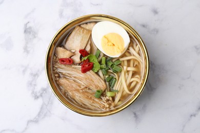 Photo of Tasty ramen with enoki and king oyster (eryngii) mushrooms on white marble table, top view