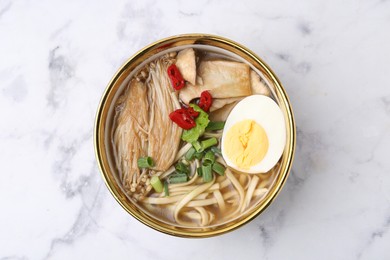 Photo of Tasty ramen with enoki and king oyster (eryngii) mushrooms on white marble table, top view