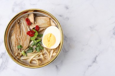 Photo of Tasty ramen with enoki and king oyster (eryngii) mushrooms on white marble table, top view. Space for text