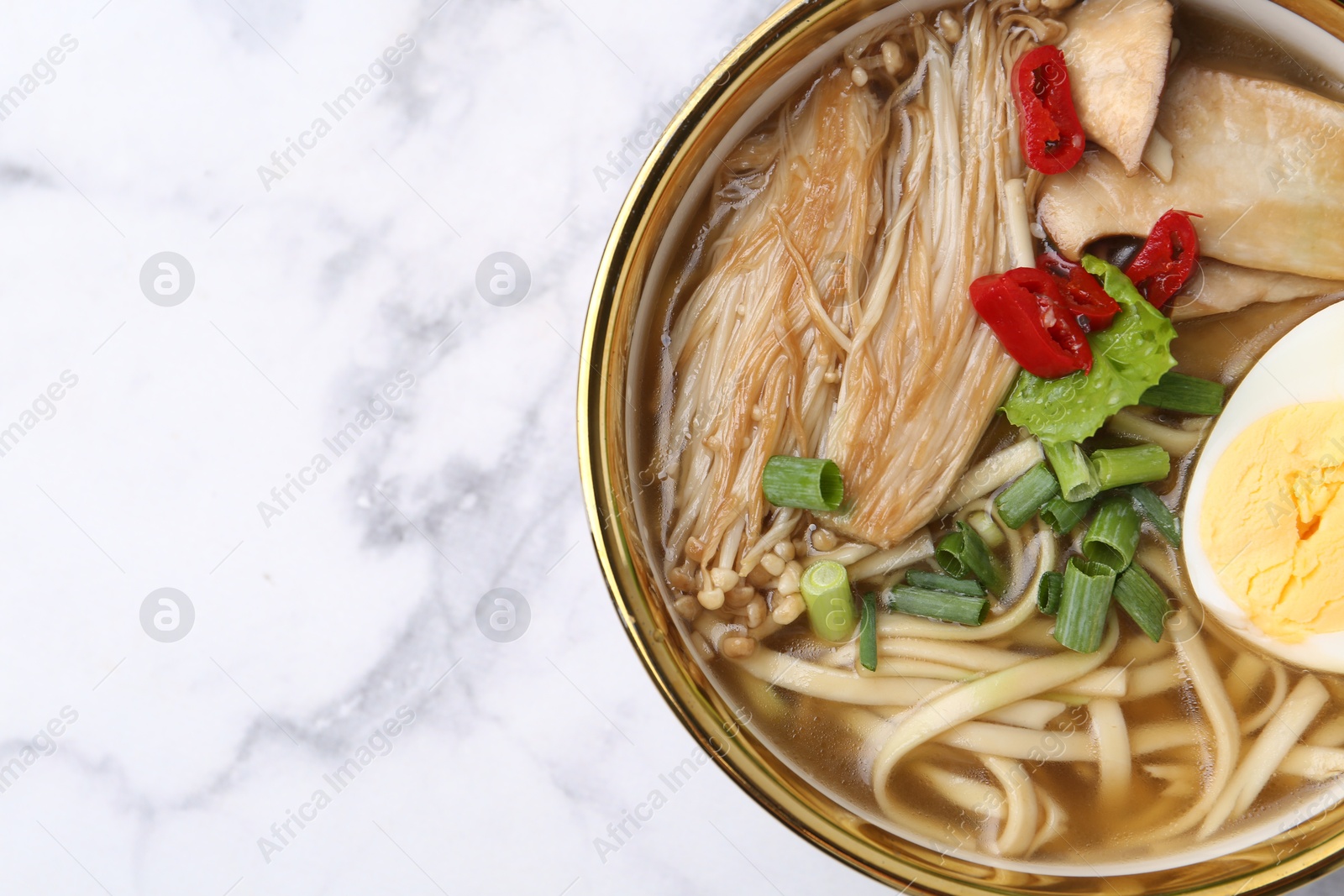 Tasty ramen with enoki and king oyster (eryngii) mushrooms on white marble table, top view. Space for text Photo of Tasty ramen with enoki and king oyster (eryngii) mushrooms on white marble table, top view. Space for text