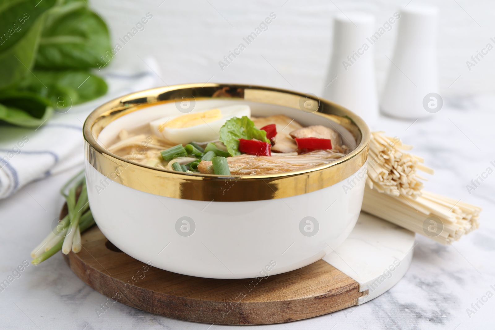 Tasty ramen with enoki and king oyster (eryngii) mushrooms on white marble table, closeup Photo of Tasty ramen with enoki and king oyster (eryngii) mushrooms on white marble table, closeup