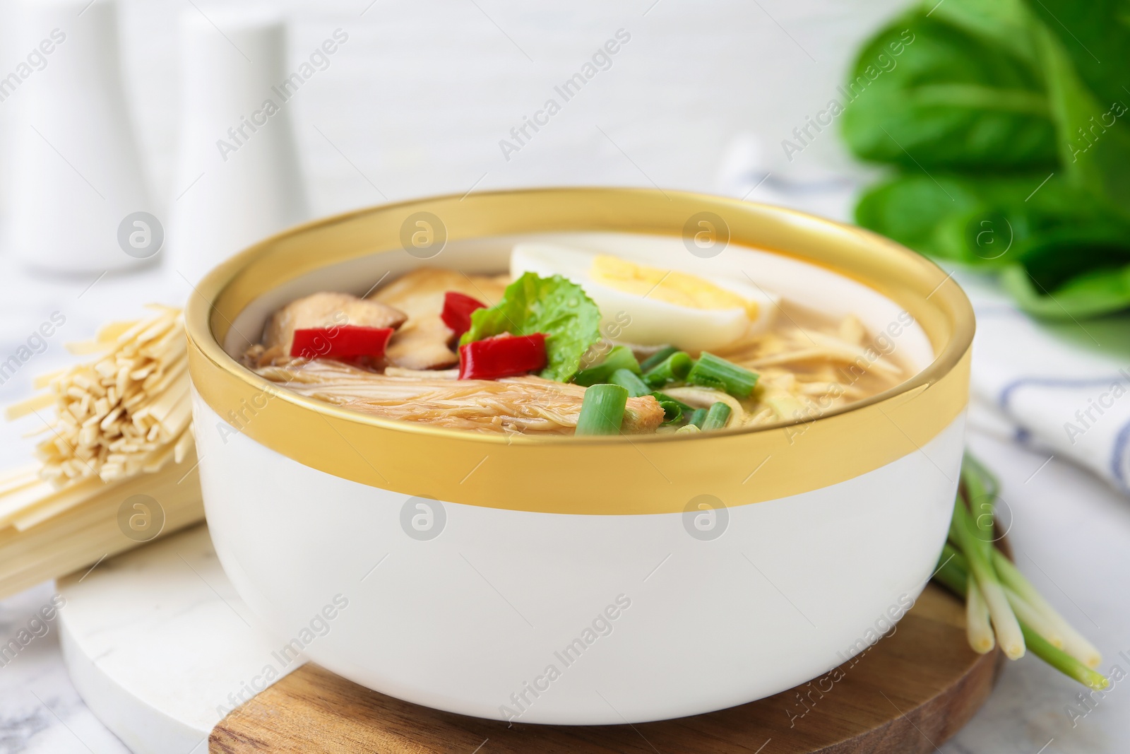 Tasty ramen with enoki and king oyster (eryngii) mushrooms on white marble table, closeup Photo of Tasty ramen with enoki and king oyster (eryngii) mushrooms on white marble table, closeup