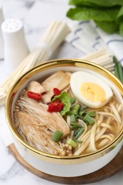 Photo of Tasty ramen with enoki and king oyster (eryngii) mushrooms on white marble table, closeup