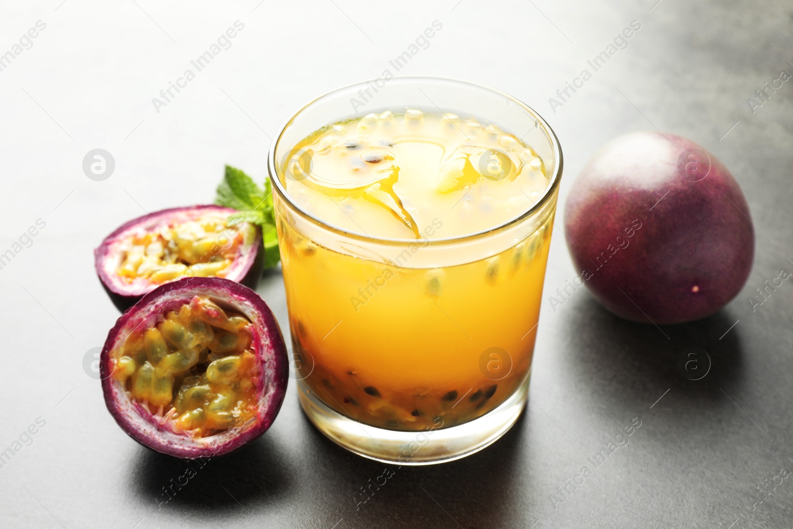 Tasty passion fruit drink with mint and fresh fruits on grey table, closeup Photo of Tasty passion fruit drink with mint and fresh fruits on grey table, closeup