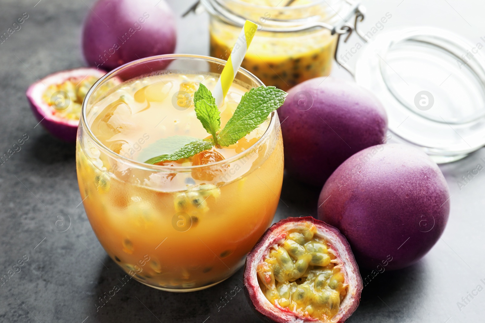 Tasty passion fruit drink with mint and fresh fruits on grey table, closeup Photo of Tasty passion fruit drink with mint and fresh fruits on grey table, closeup