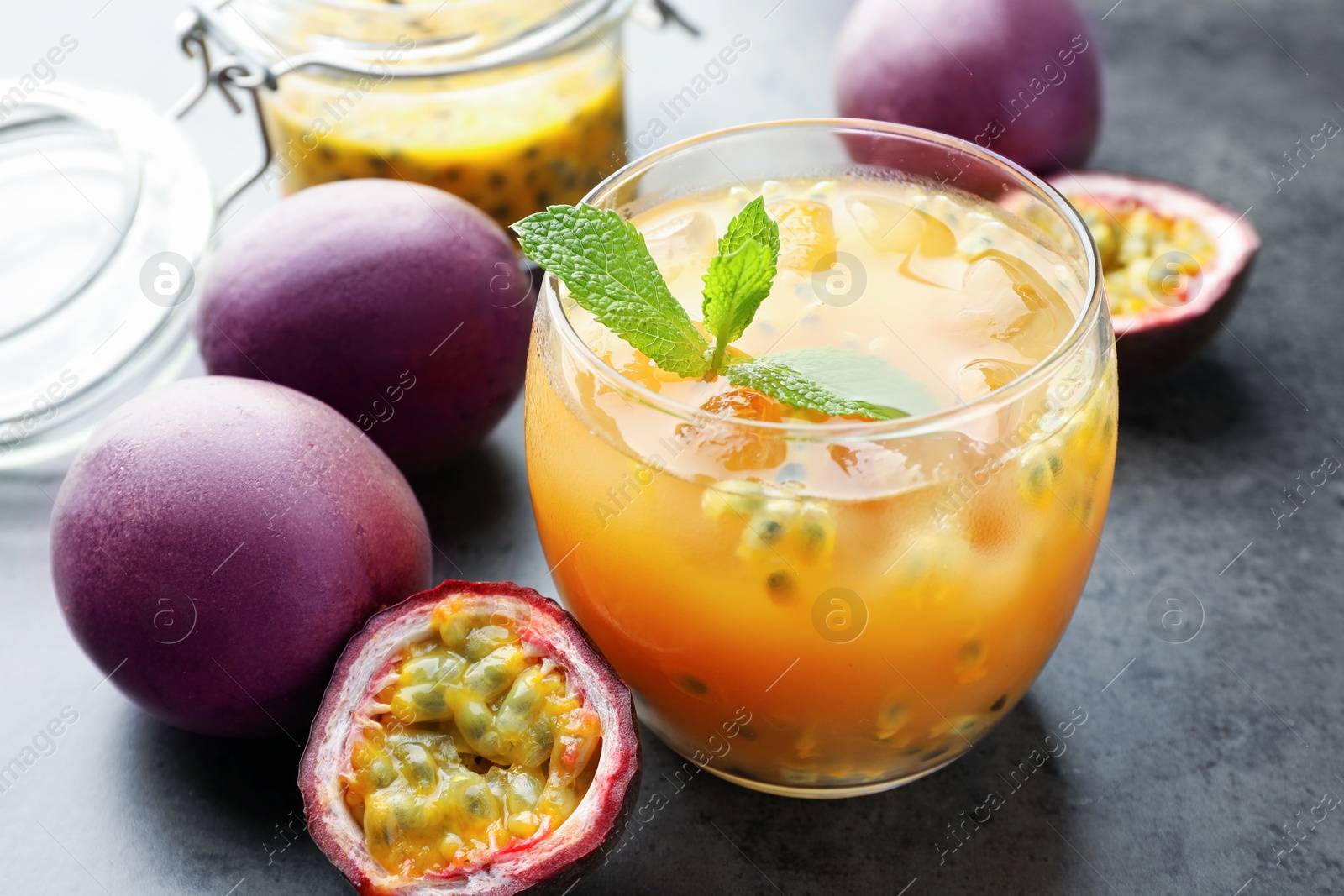 Tasty passion fruit drink with mint and fresh fruits on grey table, closeup Photo of Tasty passion fruit drink with mint and fresh fruits on grey table, closeup