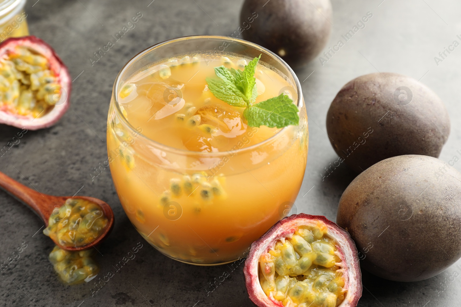 Tasty passion fruit drink with mint and fresh fruits on grey table, closeup Photo of Tasty passion fruit drink with mint and fresh fruits on grey table, closeup