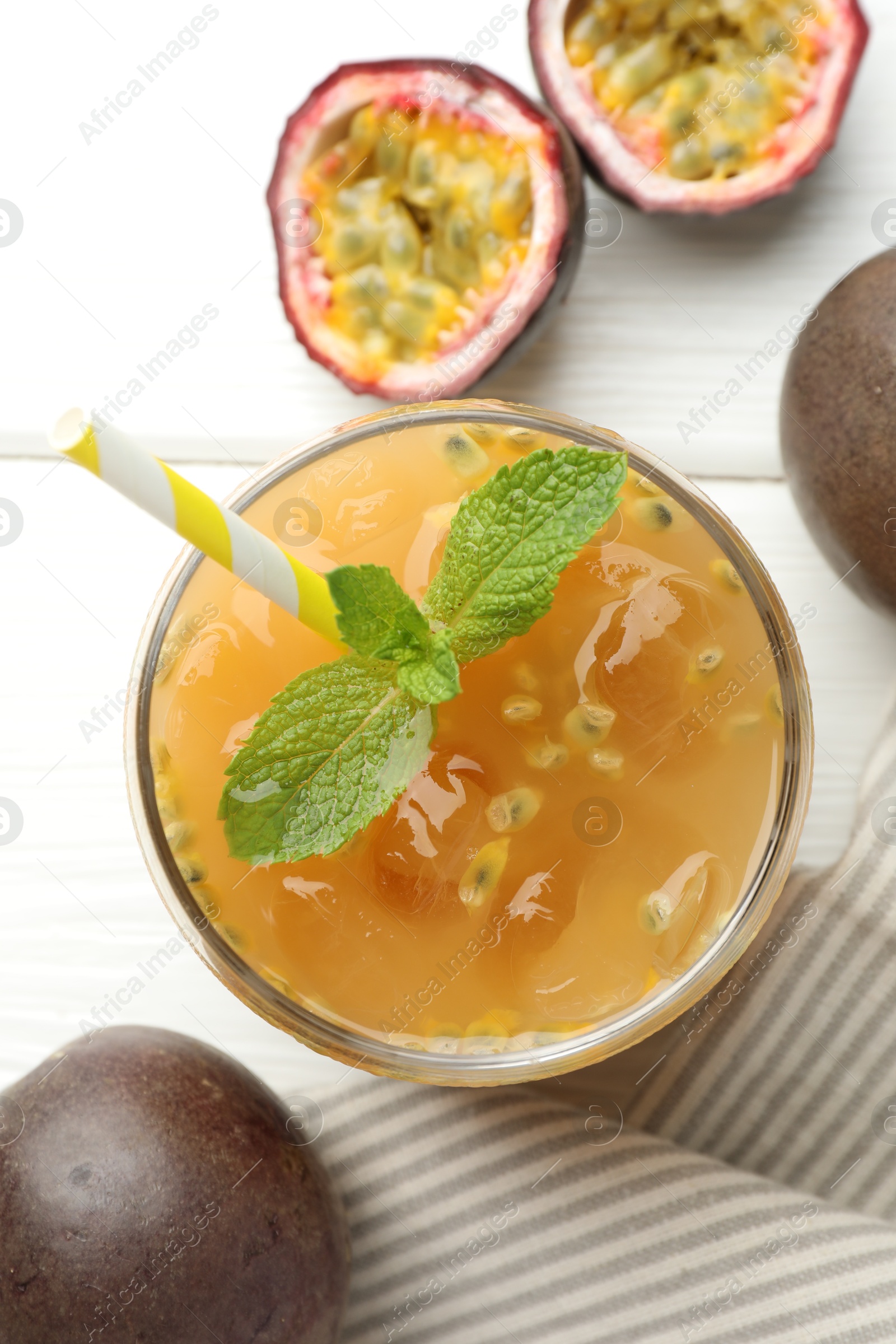 Photo of Tasty passion fruit drink with mint and fresh fruits on white wooden table, flat lay