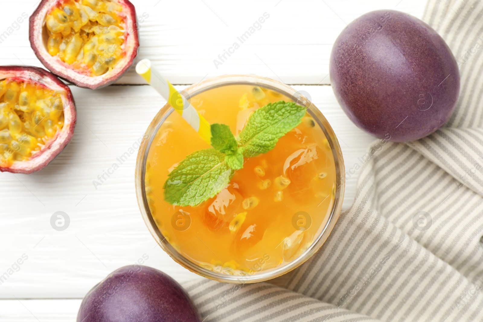 Photo of Tasty passion fruit drink with mint and fresh fruits on white wooden table, flat lay