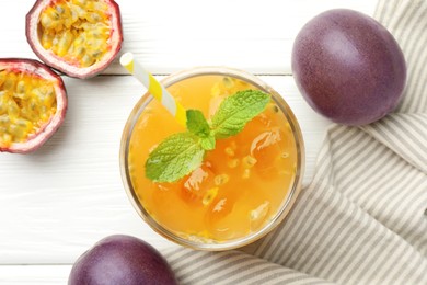 Photo of Tasty passion fruit drink with mint and fresh fruits on white wooden table, flat lay