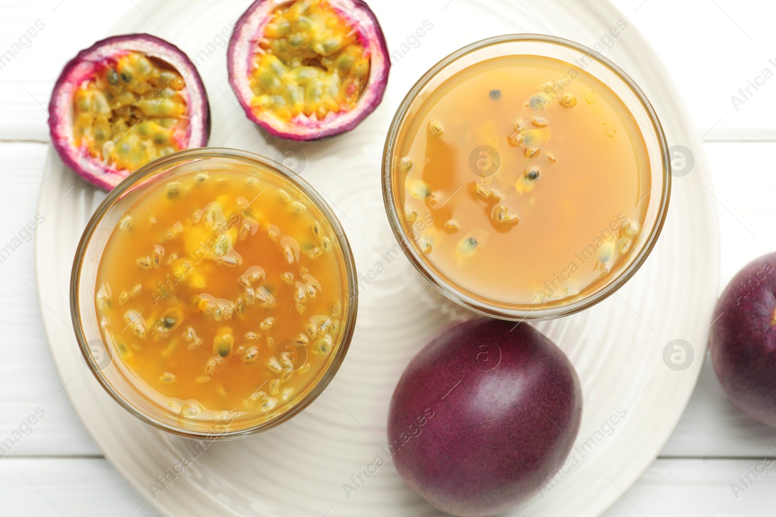 Photo of Tasty passion fruit drink and fresh fruits on white wooden table, flat lay