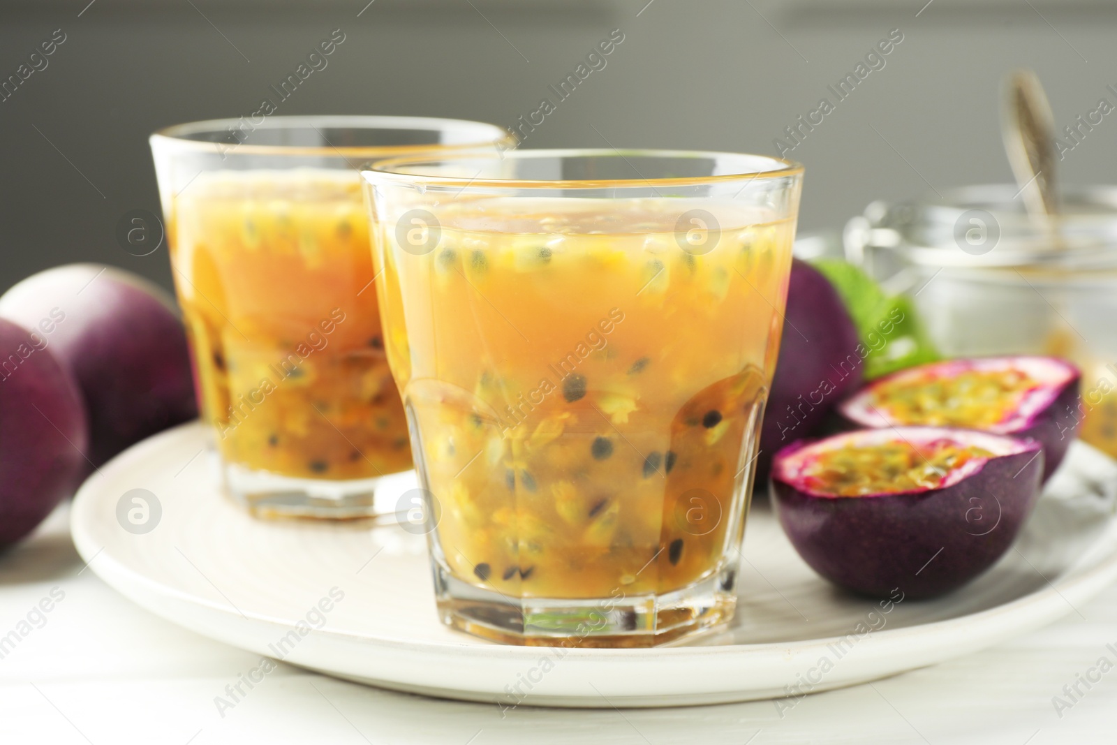 Tasty passion fruit drink and fresh fruits on white wooden table, closeup Photo of Tasty passion fruit drink and fresh fruits on white wooden table, closeup