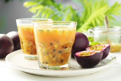 Photo of Tasty passion fruit drink and fresh fruits on white wooden table, closeup