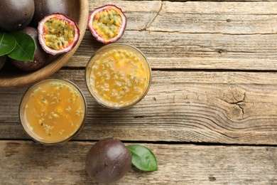Photo of Tasty passion fruit drink and fresh fruits on wooden table, flat lay. Space for text