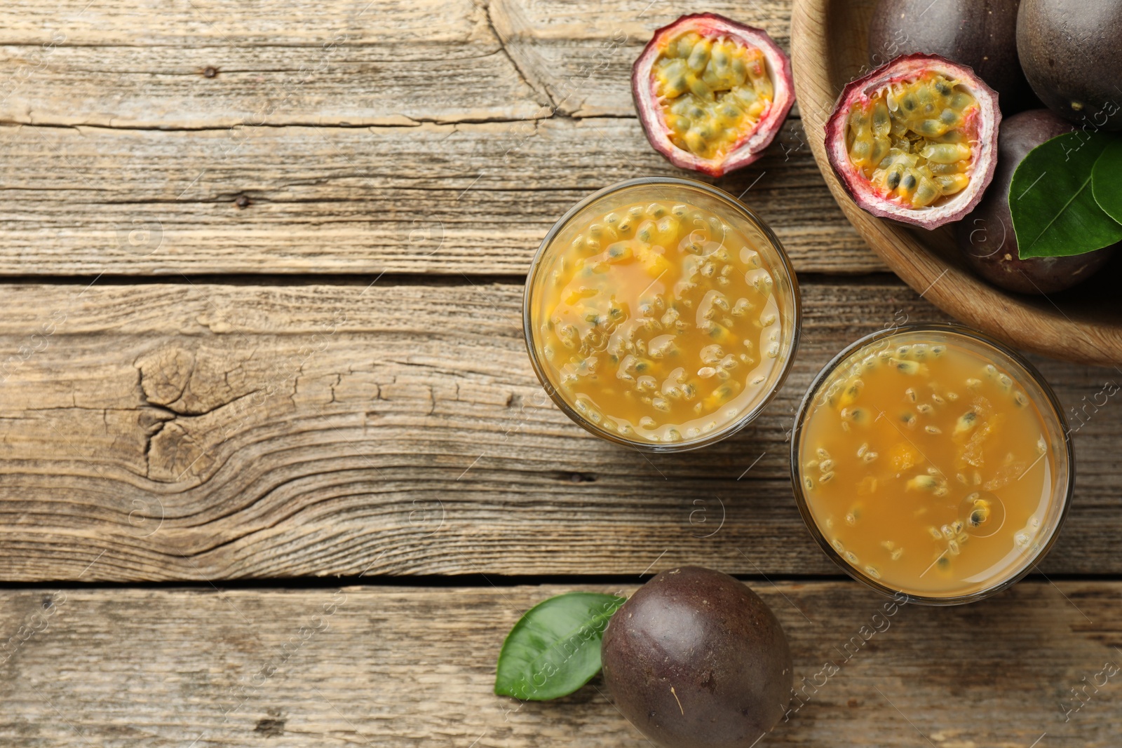 Photo of Tasty passion fruit drink and fresh fruits on wooden table, flat lay. Space for text