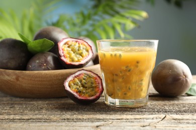 Photo of Tasty passion fruit drink and fresh fruits on wooden table, closeup