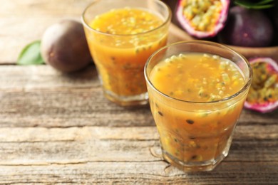 Photo of Tasty passion fruit drink and fresh fruits on wooden table, closeup. Space for text