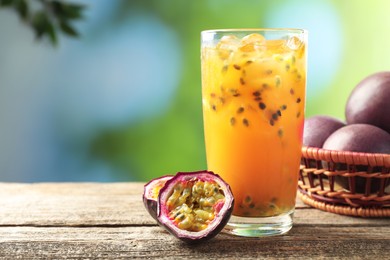 Photo of Tasty passion fruit drink and fresh fruits on wooden table, closeup. Space for text