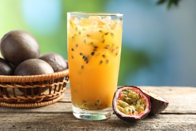 Photo of Tasty passion fruit drink and fresh fruits on wooden table, closeup