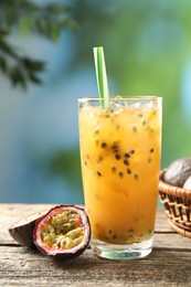 Photo of Tasty passion fruit drink and fresh fruits on wooden table