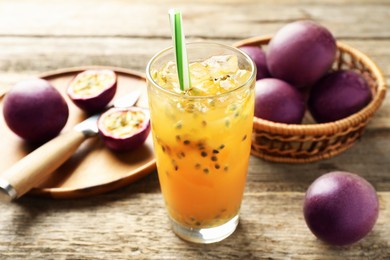 Photo of Tasty passion fruit drink and fresh fruits on wooden table, closeup